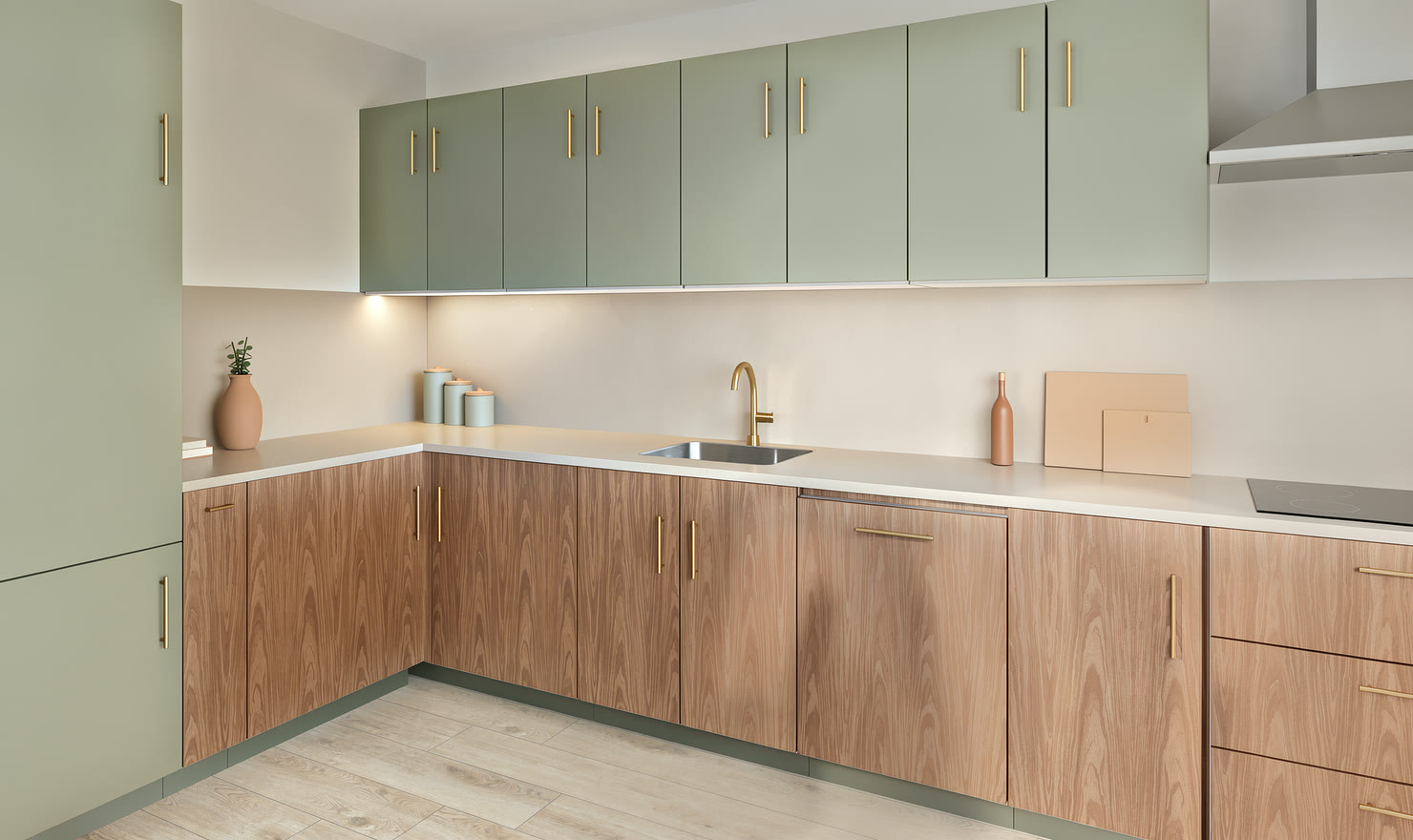 Sage cabinets and walnut in a compact L-shaped kitchen